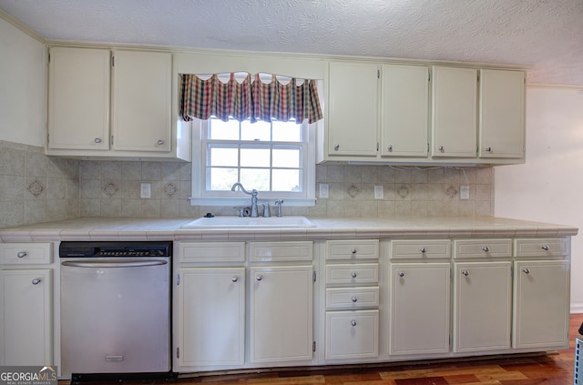 kitchen featuring stainless steel dishwasher, tile counters, sink, and hardwood / wood-style floors