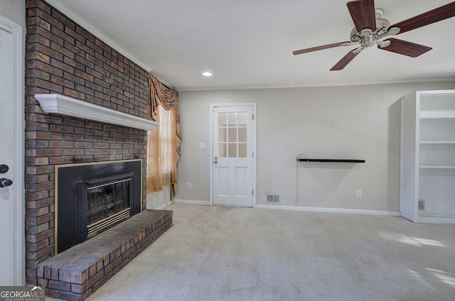 unfurnished living room with a fireplace, ceiling fan, crown molding, and light carpet