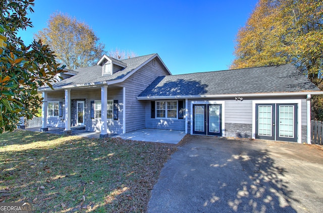 view of front of house with french doors, a front lawn, and a patio