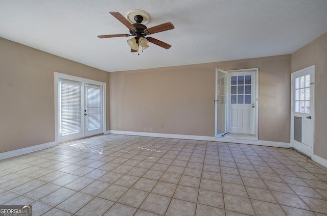 interior space with ceiling fan, french doors, light tile patterned floors, and a textured ceiling