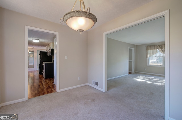 spare room featuring wood-type flooring and a textured ceiling