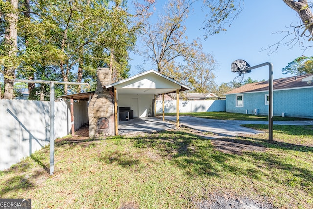 view of yard with central AC unit and a carport