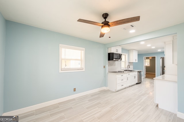 kitchen featuring appliances with stainless steel finishes, tasteful backsplash, ceiling fan, sink, and white cabinetry