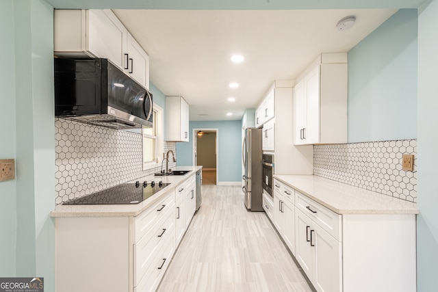 kitchen featuring decorative backsplash, white cabinetry, sink, and stainless steel appliances