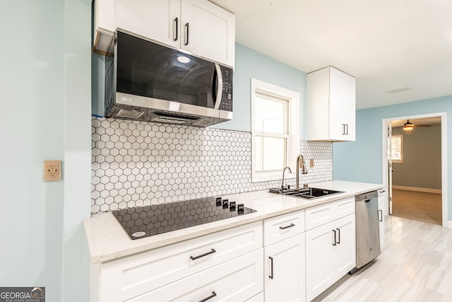 kitchen with white cabinets, plenty of natural light, sink, and stainless steel appliances