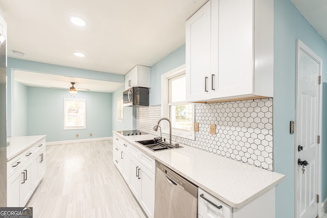 kitchen featuring decorative backsplash, stainless steel appliances, white cabinetry, and sink