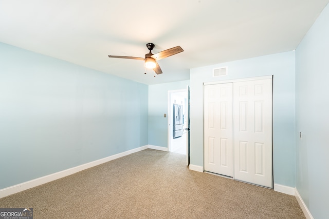 unfurnished bedroom with stainless steel fridge, carpet floors, a closet, and ceiling fan