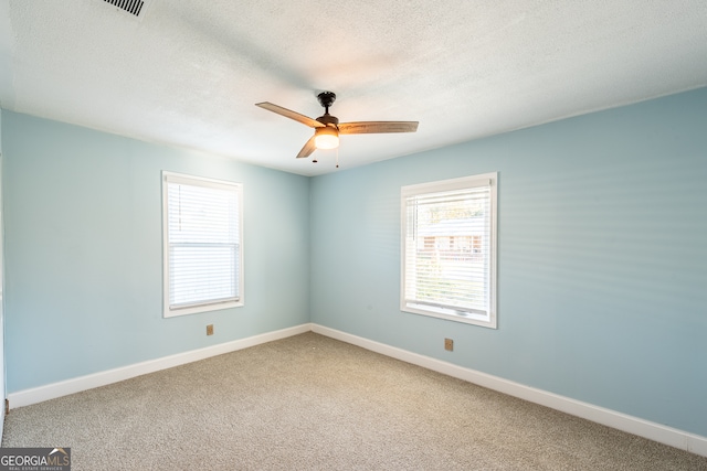 carpeted empty room featuring ceiling fan and a textured ceiling