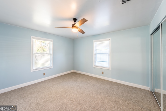 unfurnished bedroom with carpet flooring, ceiling fan, and a closet