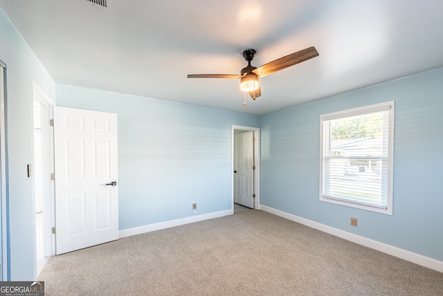 carpeted spare room with ceiling fan