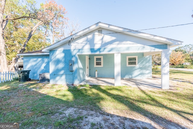 rear view of house with a yard, cooling unit, and a patio