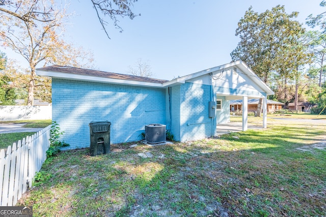 back of property featuring a lawn and central AC