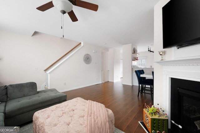 living room featuring ceiling fan and dark hardwood / wood-style floors