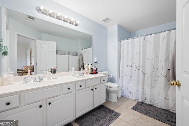 bathroom featuring tile patterned flooring, a shower with curtain, vanity, and toilet