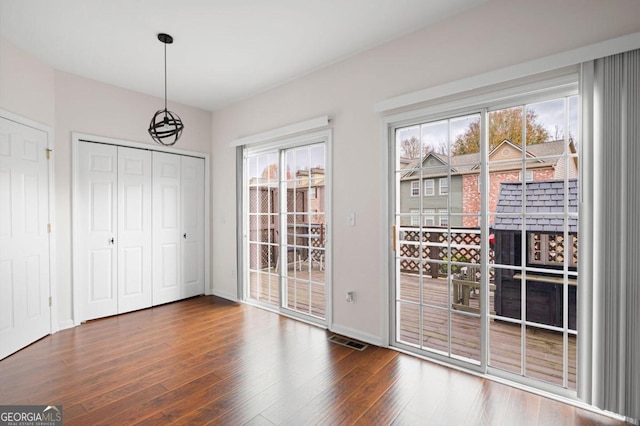 entryway with a notable chandelier and dark hardwood / wood-style flooring