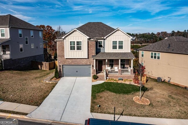 view of front of house featuring a porch, a front yard, and a garage