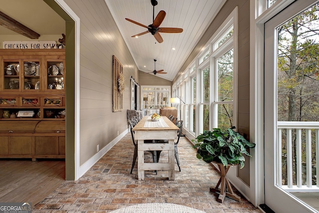 sunroom / solarium featuring a healthy amount of sunlight and vaulted ceiling