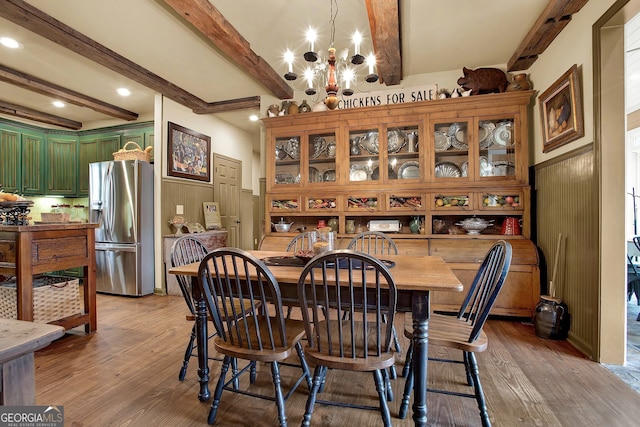 dining space featuring beam ceiling, an inviting chandelier, and light wood-type flooring