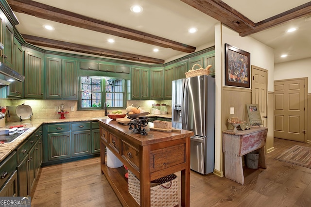 kitchen featuring sink, light hardwood / wood-style flooring, stainless steel fridge, beamed ceiling, and light stone counters