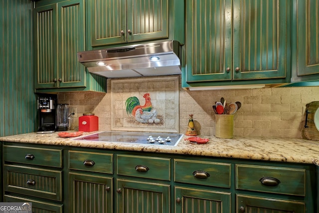 kitchen featuring white cooktop, light stone countertops, backsplash, and green cabinetry