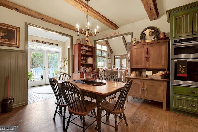 dining area featuring lofted ceiling with beams, french doors, dark wood-type flooring, and a notable chandelier