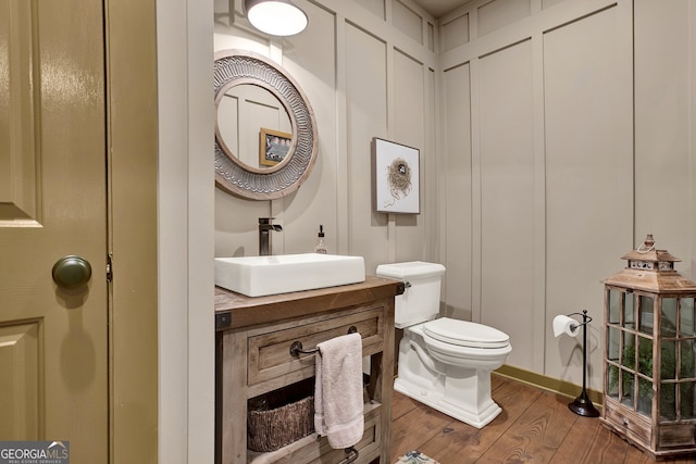 bathroom featuring wood-type flooring, vanity, and toilet