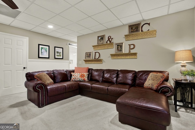 living room featuring a paneled ceiling and light carpet