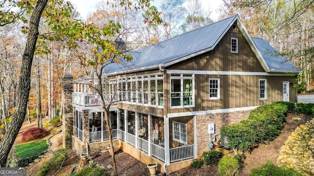 back of property featuring a balcony and a sunroom