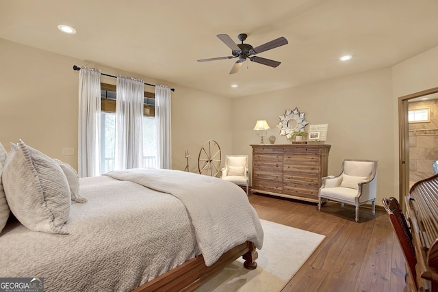 bedroom featuring hardwood / wood-style floors, multiple windows, and ceiling fan