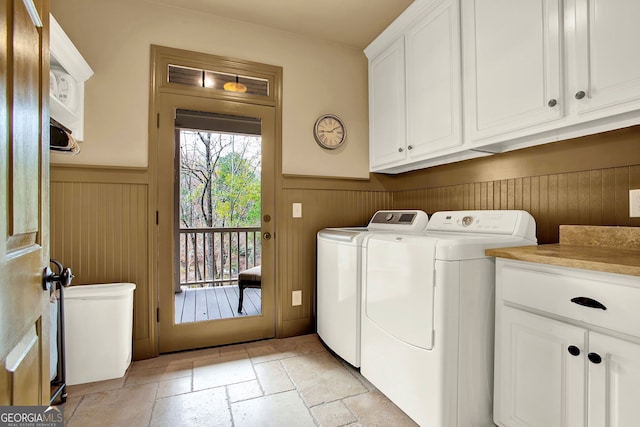 laundry area featuring wood walls, cabinets, and independent washer and dryer