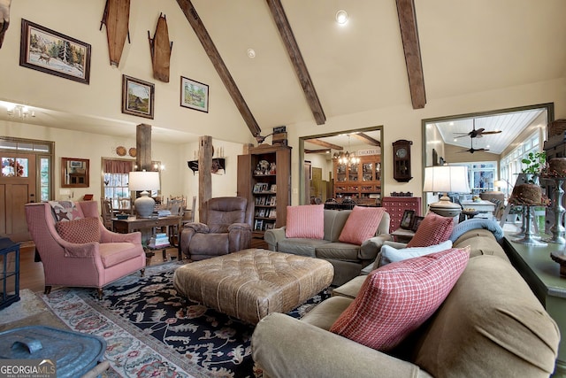 living room with beamed ceiling, ceiling fan with notable chandelier, and high vaulted ceiling