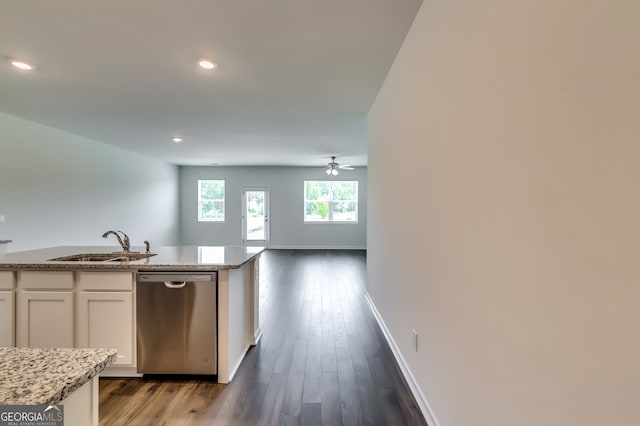 kitchen with white cabinets, sink, stainless steel dishwasher, dark hardwood / wood-style floors, and light stone counters