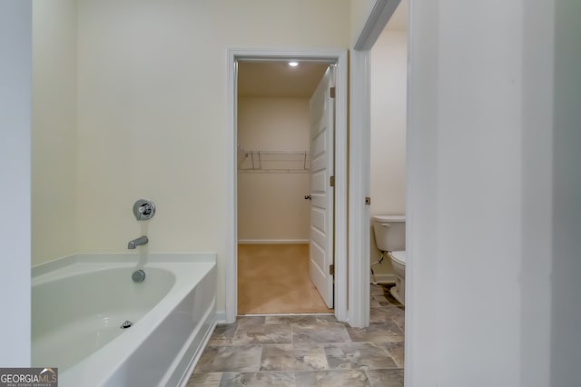 bathroom featuring a bath and toilet