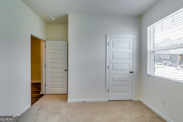 unfurnished bedroom featuring light carpet