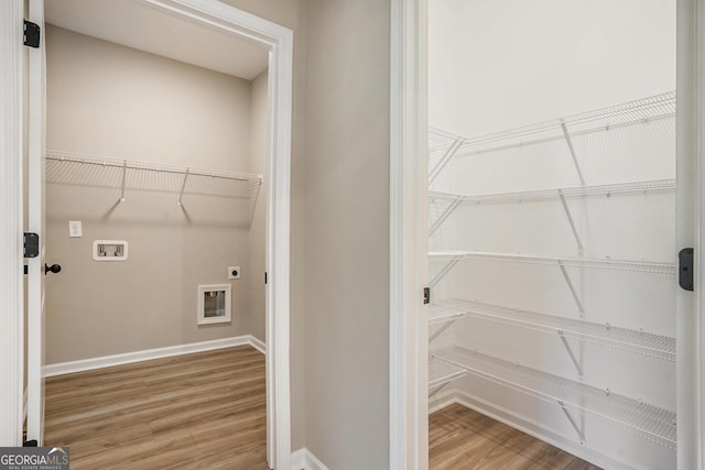 washroom featuring hookup for an electric dryer, hookup for a washing machine, and hardwood / wood-style flooring