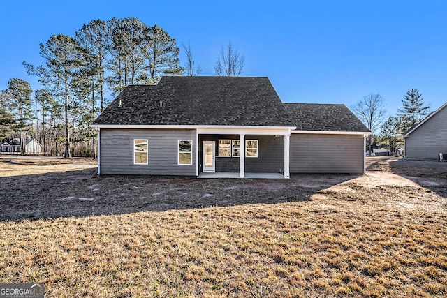 rear view of property featuring a lawn and a patio area