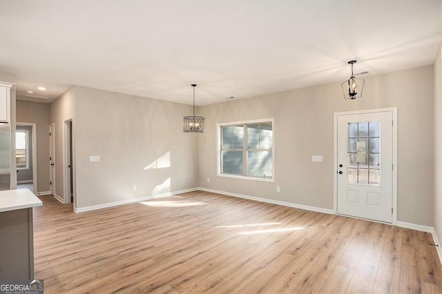 interior space with light hardwood / wood-style floors and a notable chandelier