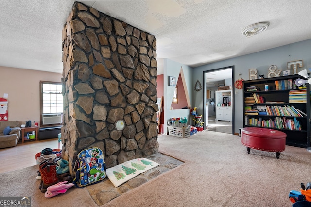 playroom featuring cooling unit, carpet floors, and a textured ceiling