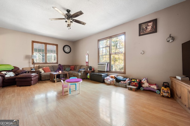 living room featuring light wood-type flooring, a wealth of natural light, and ceiling fan