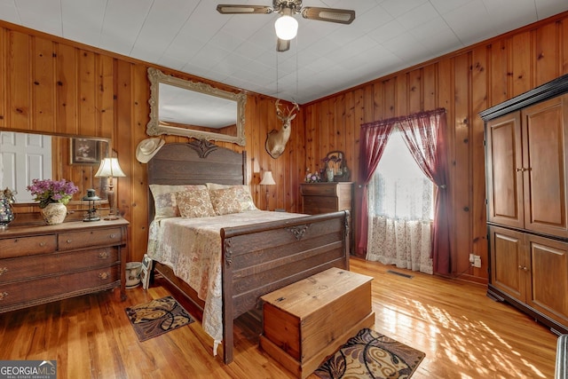 7667 Tallahassee Hwy, Attapulgus, GA 39815 - bedroom featuring light wood-style floors, wood walls, and ceiling fan