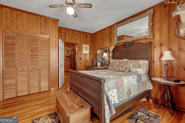 7667 Tallahassee Hwy, Attapulgus, GA 39815 - bedroom featuring wood walls, light wood-style floors, a closet, and ceiling fan