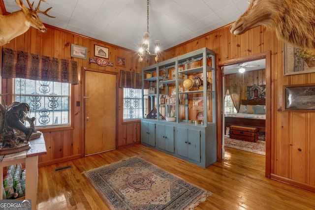 interior space featuring plenty of natural light, light wood-type flooring, and wooden walls