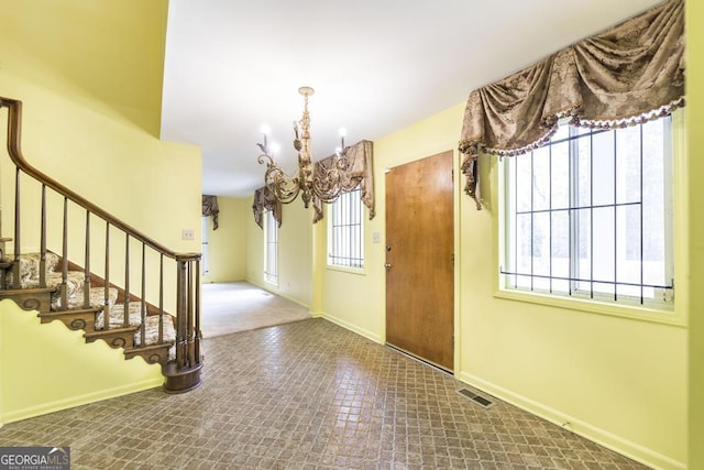 6909 Forsyth Rd, Macon, GA 31210 - foyer with a chandelier, stairs, and tile patterned floors