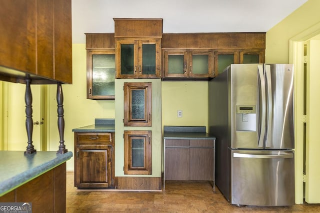 6909 Forsyth Rd, Macon, GA 31210 - kitchen featuring stainless steel fridge, dark countertops, and glass insert cabinets