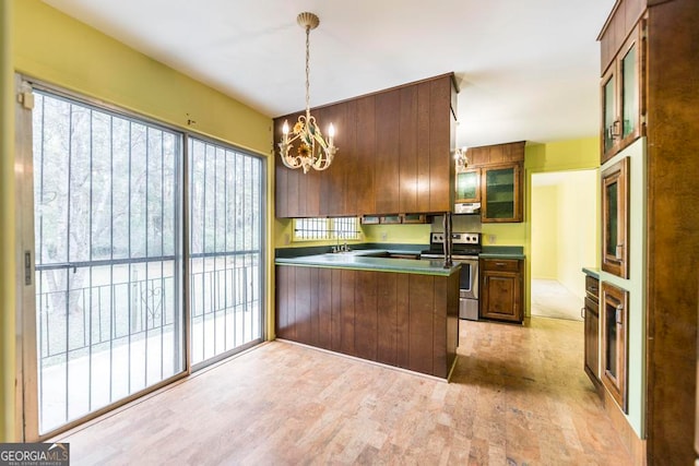 kitchen featuring kitchen peninsula, decorative light fixtures, stainless steel range with electric stovetop, and light hardwood / wood-style floors