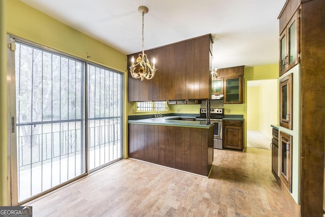 6909 Forsyth Rd, Macon, GA 31210 - kitchen with electric range, a chandelier, light wood-style flooring, a peninsula, and glass insert cabinets