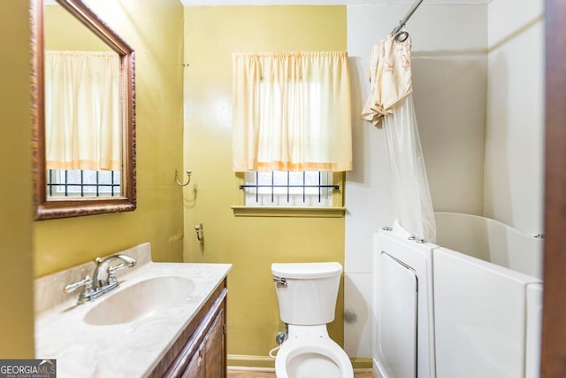 full bathroom featuring shower / bath combo, vanity, and toilet