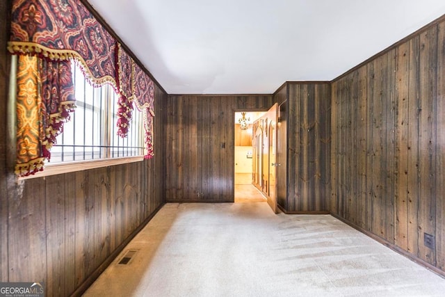 carpeted empty room with wood walls