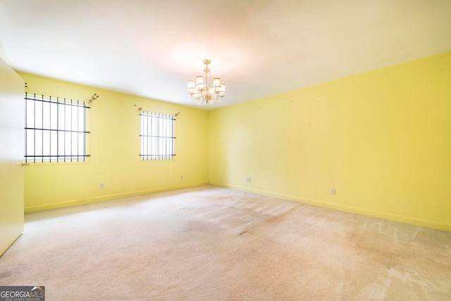 unfurnished room with light carpet and an inviting chandelier