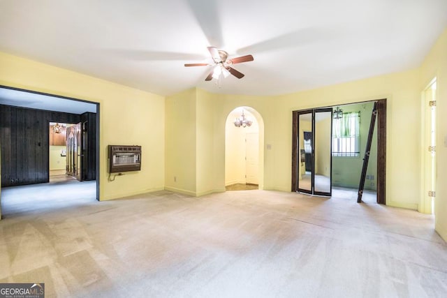 empty room with heating unit, ceiling fan, and light colored carpet